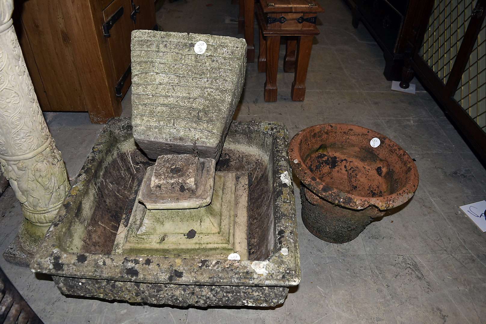 A reconstituted stone pedestal planter, the square top on stepped base, 50 cm square, together