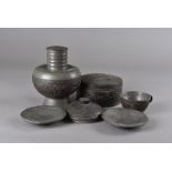 A late 19th Century pewter and coconut shell tea service, comprising teapot, sugar bowl and cover,