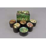 Seven Russian papier mache boxes, comprising six oval examples with painted landscapes and a green