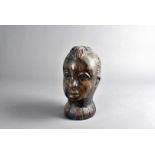 A carved African head, modelled as a female, 24 cm high