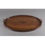 An Edwardian mahogany oval tray, having string inlay, raised gallery sides and twin brass handles,