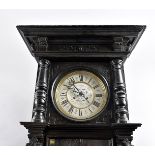 An Edwardian ebonised Vienna style wall clock, with eight day movement within an ornate carved
