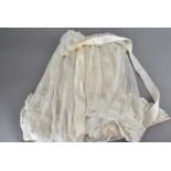 An early 20th Century christening robe, the lace exterior with embroidered stylised floral design