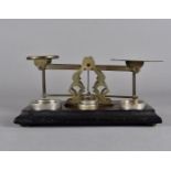A Morden & Co set of scales, on coromandel base, with weights, 17 cm x 14 cm x 13 cm high