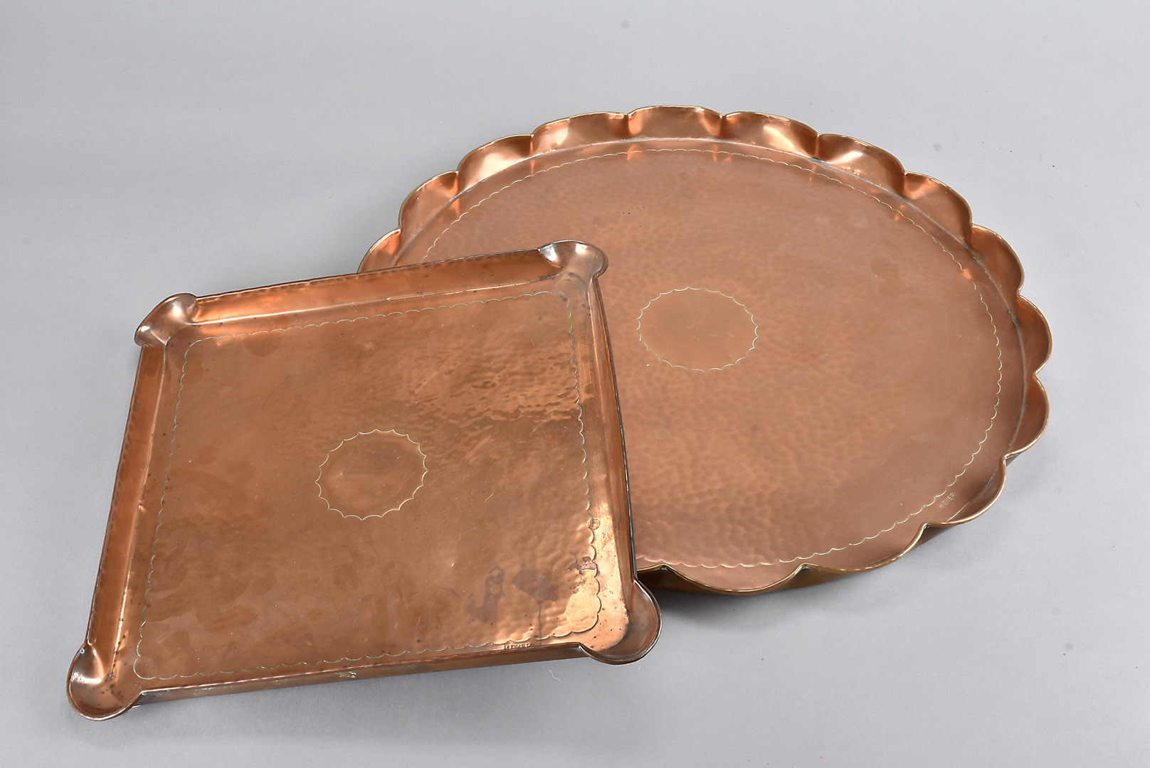 Two Herbert Dyer copper arts and crafts trays, one of square shape, 27 cm square, the other circular