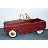 A 1950s Triang Lightning tinplate child's pedal car, later painted red, with Triang marked to