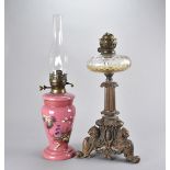 A 19th Century cast iron and glass oil lamp, having three lion and shield legs with column design,