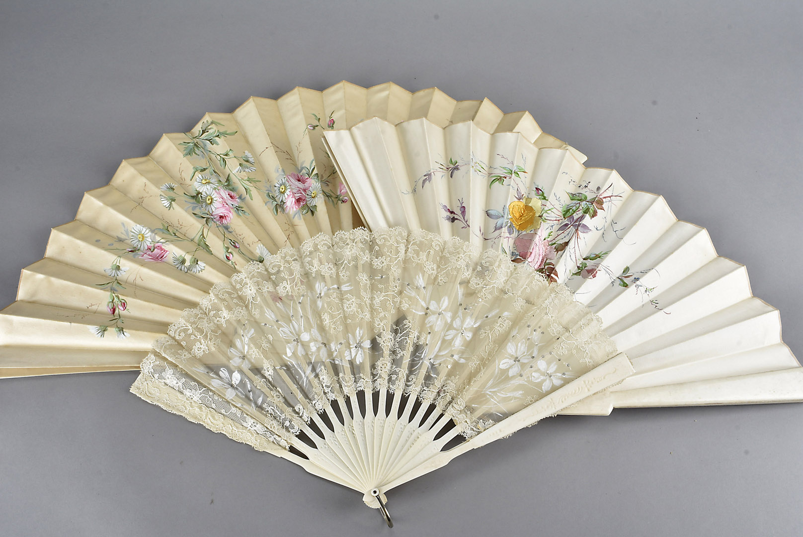 A group of three Victorian and Edwardian bone fans, two with silk leaves having painted designs, and