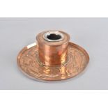 A Newlyn arts and crafts copper inkwell, the cylindrical drum with glass well supported on a