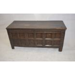 An 18th Century oak panel chest, the front section with carved frieze over stylised flowers and