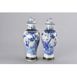 A pair of Oriental blue and white vases and covers, the white ground having blue figural