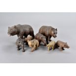 A collection of eight carved Black Forest bears, some with glass eyes and painted mouths, largest 24