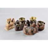 A collection of six carved Black Forest bears, all modelled on their backs holding brass bowls and