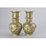 A pair of Chinese brass dragon vases, of ovoid form with straight necks decorated with dragons