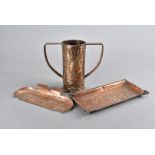 An arts and crafts Newlyn style copper twin handled vase, with hammer beaten design of fish swimming