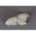 An 18th Century Chinese carved jade temple dog, modelled reclining with crossed paws with later