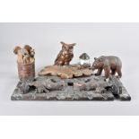 A Black Forest carved bear book trough, 39 cm long together with an owl carved desk set with pen