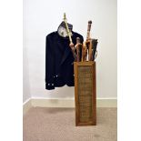A collection of walking sticks and canes, a modern stick stand, a Scottish traditional jacket and