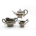 An interesting harliquin William IV silver three piece silver tea set, the squat teapot on shell