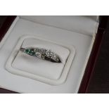 A modern 14ct white gold and diamond engagment ring and matching diamond and emerald wedding ring by