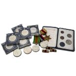 A collection of coins and medals, including three WWII medals with carboard marked for W.H.K