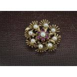 A 1970s 9ct gold pearl and ruby pendant, flower head style mount set with nine pearls and small
