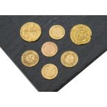 A group of seven gold and yellow metal coins, including two French 5 Francs, three Middle Eastern