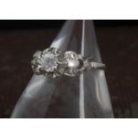 An Art Deco period platinum and diamond engagement ring, having a central brilliant cut and six rose