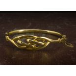 An Edwardian 9ct gold bangle, with knot style tablet, 7.3cm