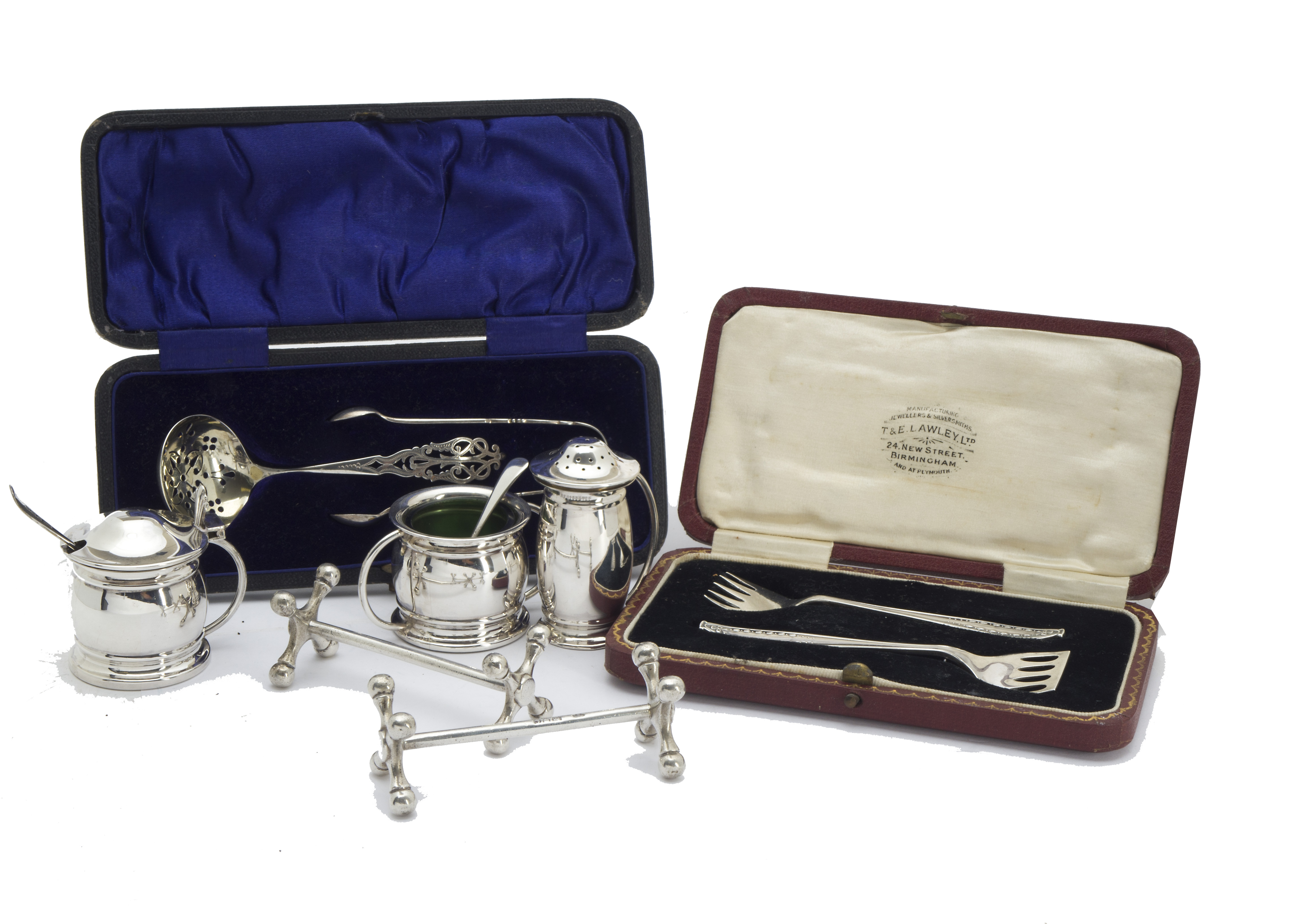 A George V silver three piece cruet set by L & S, with two spoons, together with a pair of silver