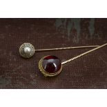 Two Victorian stick pins, one a larger cabochon garnet, the other a cluster with paste and simulated