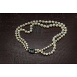 A two strand pearl necklace, the graduating white cultured pearls with silver and paste set clasp