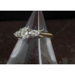 A pretty diamond engagement ring, haivng a modern round brilliant cut of 0.8ct flanked by a pair