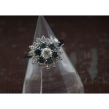 A modern 14ct white gold diamond cluster ring, central brilliant cut within heat trated teal diamond