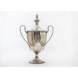 A George III silver trophy cup and cover by William Holmes, the twin ear loop applied handles on