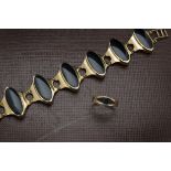 A modern 9ct gold and black onyx bracelet and ring, the elongated black panels in seven gold