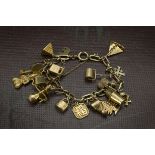 A vintage 9ct gold and yellow metal charm bracelet, flattened oval pierced link chain with