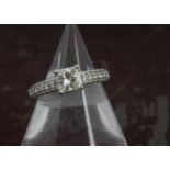 A modern 14ct white gold and diamond engagment ring, having a princess cut stone of approx 1ct in
