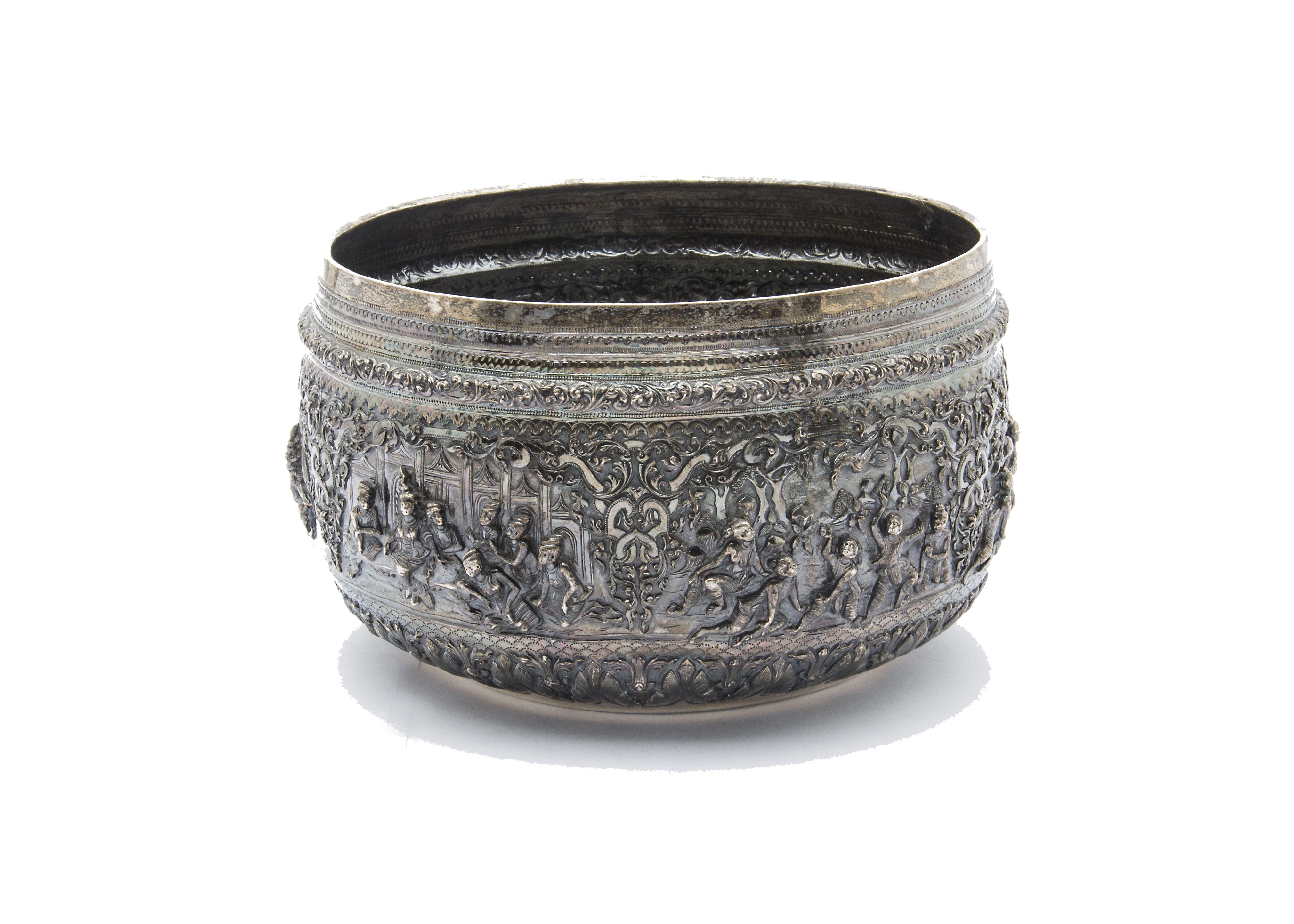 A large 19th century Indian silver bowl, having intricate embossed scenes of figures with ornate
