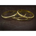 Four 1970s Middle Eastern gold bangles, each of differing designs, 7cm inner diameter, 55g (4)