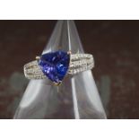 A modern tanzanite and diamond dress ring from Rocks & Co, the 18ct gold mount with pierced