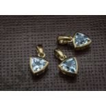 A group of three modern 9ct gold and aqua marine pendant, triangular light blue stone, perfect as