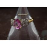 A modern 18ct gold pink sapphire and diamond ring, oval pink stone with two sets of three princess