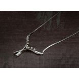 A 1970s white gold and diamond necklace, with wishbone style lower set with seven brilliant cuts,