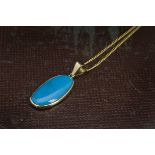 A gold and turquoise pendant, on a gold plated fine chain