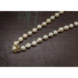 A single strand pearl necklace, baroque style freshwater cultured pearls with 14k marked clasp