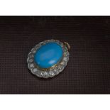 An Edwardian period turquoise and diamond pendant, the oval cabochon blue stone in gold and white