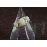 A Victorian 18ct gold opal and diamond ring, having three oval opals and four old cut stones,