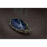 A 1970s silver and lapis lazuli brooch, the oval blue hardstone panel in abtract mount, similar to