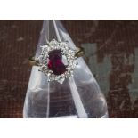 A modern ruby and diamond cluster dress ring, the large oval Thai ruby surrounded by brilliant cuts,